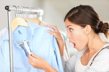 women in clothing store shocked at price of a shirt