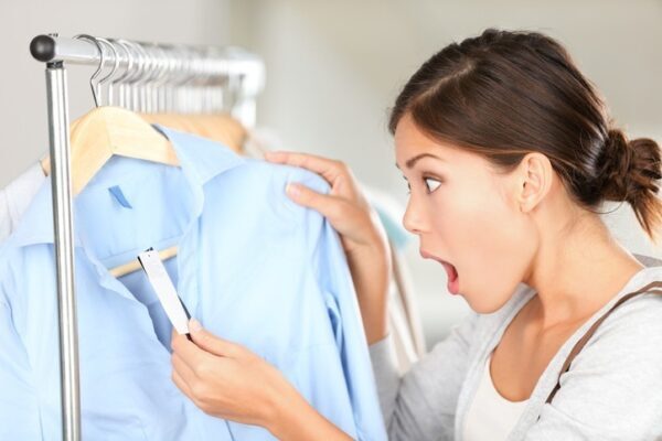 women in clothing store shocked at price of a shirt