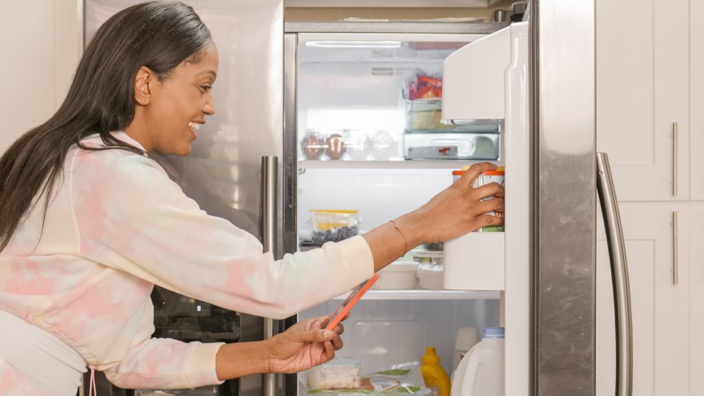 Woman scanning food in her fridge with her phone